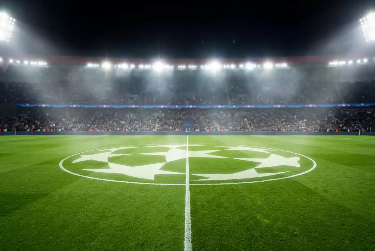 Champions-League-Spielfeld bei Nacht mit Sternebanner am Mittelkreis