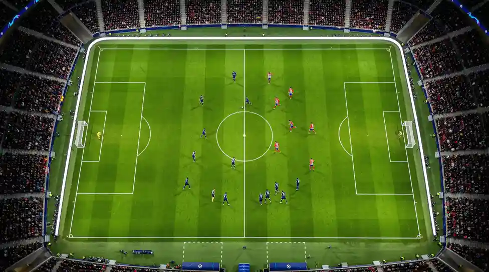 Fußballfeld von oben mit markierten Spielerpositionen bei einem Abendspiel